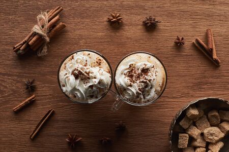 top view of Christmas cacao with whipped cream on wooden table with anise, brown sugar and cinnamonの写真素材