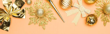 top view of festive golden christmas decoration on orange background, panoramic shotの写真素材