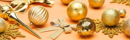 festive shiny golden christmas decoration on orange background, panoramic shot
