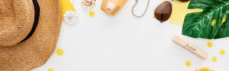 panoramic shot of wooden block with june inscription, sunglasses, straw hat, sunscreen, lollipops, sunscreen isolated on whiteの写真素材