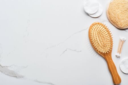 top view of cotton pads and swabs near hair brush and face sponge on marble surfaceの写真素材