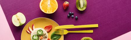 top view of plate with fancy cow made of food near fruits on purple background, panoramic shotの写真素材