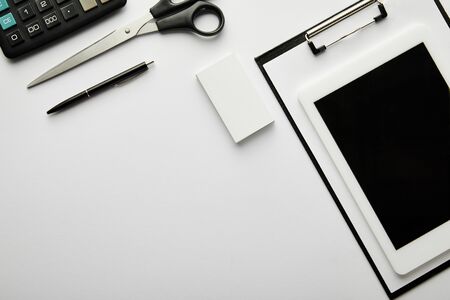 top view of clipboard, pen, business card, scissors, calculator and digital tabletの写真素材