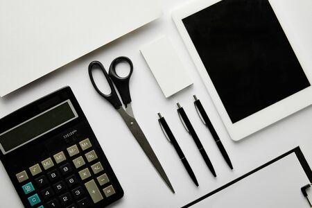 top view of clipboard, pens, business card, paper, calculator, scissors and digital tabletの写真素材