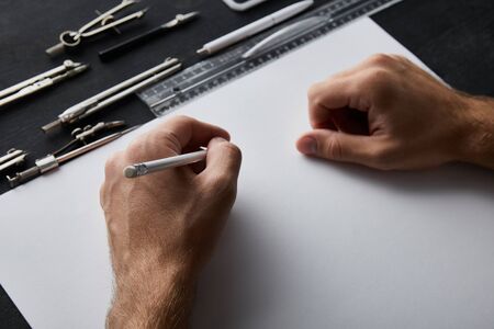 cropped view of businessman writing on paper with pencilの写真素材