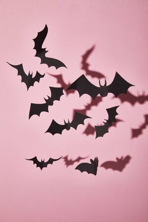 black paper bats with shadow on pink background, Halloween decoration