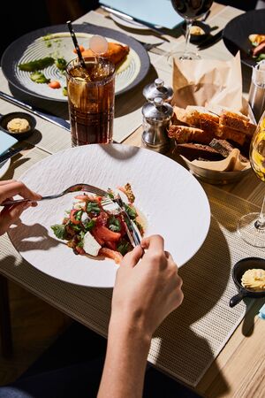 partial view of woman eating delicious eggplant caviar in restaurant