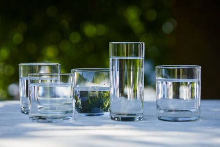 clear fresh water in transparent glasses in sunlightの写真素材