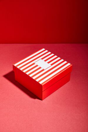 striped red gift box on red backgroundの写真素材