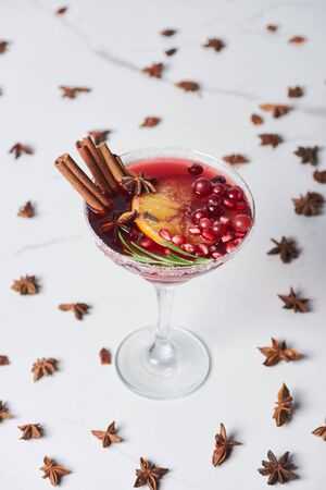 selective focus of christmas cocktail with orange, pomegranate and cinnamonの写真素材