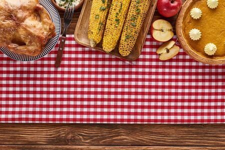 top view of pumpkin pie, turkey and vegetables served at wooden table for Thanksgiving dinnerの写真素材