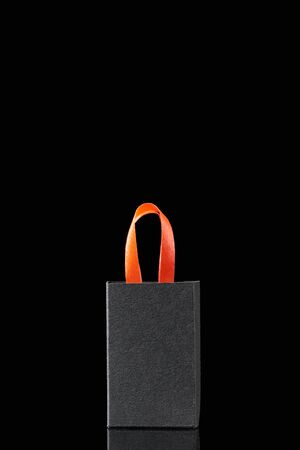 paper shopping bag with red handle isolated on blackの写真素材