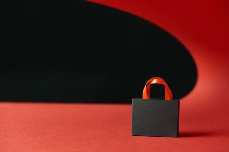 decorative shopping bag on red paper isolated on blackの写真素材