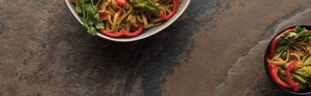 top view of thai noodles near chopsticks on stone surface, panoramic shot