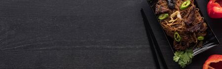 top view of meat thai noodles near chopsticks on wooden grey surface, panoramic shotの写真素材