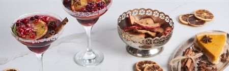 panoramic shot of christmas cocktails with orange, pomegranate, cinnamon, apple pie and dry applesの写真素材