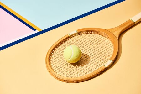 Yellow tennis ball on racket on background with blue linesの写真素材