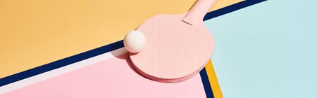 Pink table racket and ball on abstract background with blue lines, panoramic shotの写真素材
