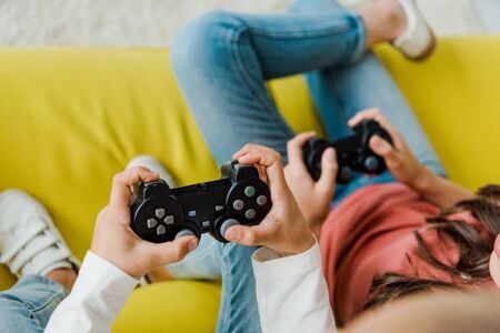 KYIV, UKRAINE - SEPTEMBER 4, 2019: selective focus of babysitter and kid playing video game in living roomのeditorial素材