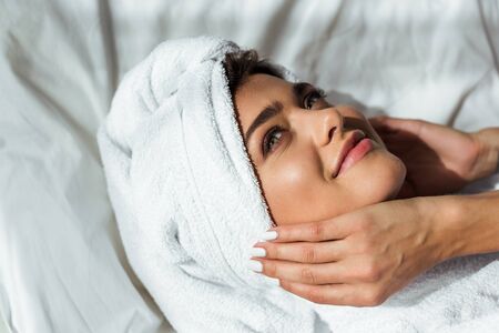 attractive woman in towel lying on bed at morning
