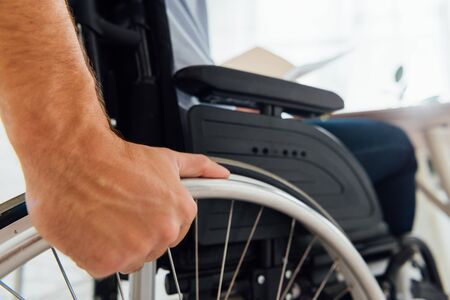 Close up of man holding wheel of wheelchairの写真素材