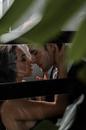 selective focus of passionate couple hugging and going to kiss in lift
