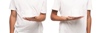 cropped view of two boys holding saucers with cups of coffee isolated on white, panoramic shotの写真素材