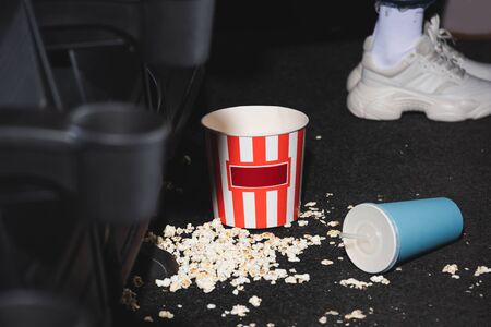 selective focus of popcorn and paper cup with soda on floor in cinemaの写真素材