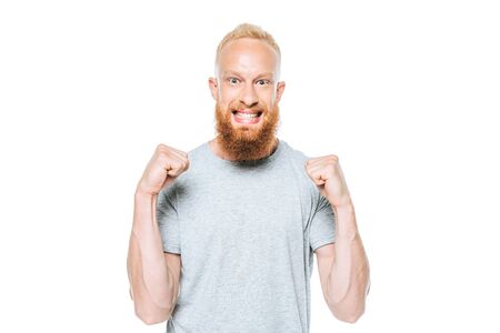 happy bearded man triumphing in grey t-shirt, isolated on whiteの写真素材