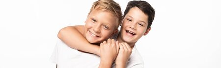 panoramic shot of cheerful boy jokingly stifling smiling brother isolated on white