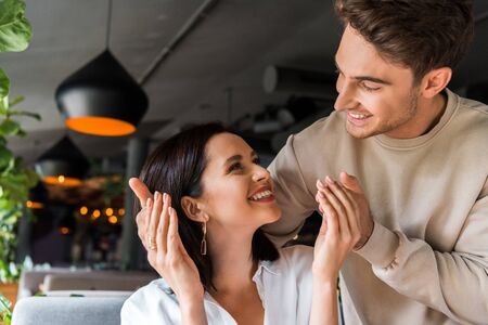 happy man looking at cheerful woman in restaurantの写真素材