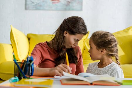 selective focus of cute kid looking at babysitter in living roomの写真素材