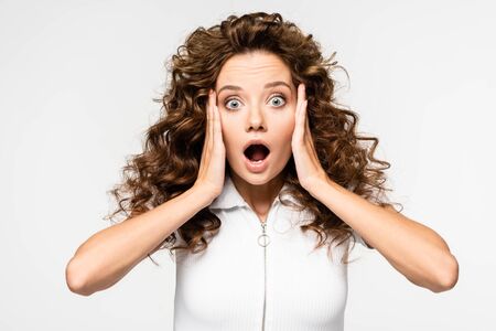 shocked curly girl gesturing in white t-shirt, isolated on white