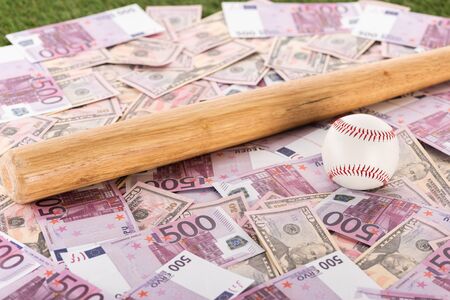 selective focus of baseball bat and ball on euro and dollar banknotes, sports betting conceptの写真素材