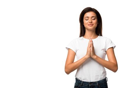 attractive woman in white t-shirt praying with hands folded together, isolated on whiteの写真素材