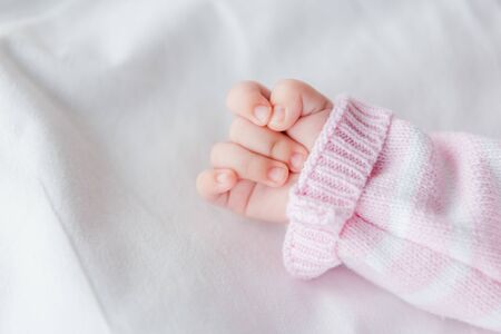 cropped view of baby lying on bedの写真素材