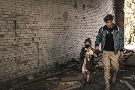 man holding hands with kid while walking on street in chernobyl, post apocalyptic conceptの写真素材