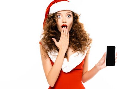 surprised girl in santa costume showing smartphone with blank screen, isolated on whiteの写真素材