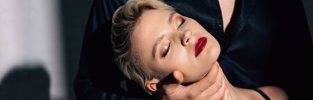 panoramic shot of man hugging attractive woman with closed eyesの写真素材