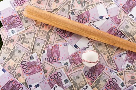 top view of baseball bat and ball on euro and dollar banknotes, sports betting conceptの写真素材