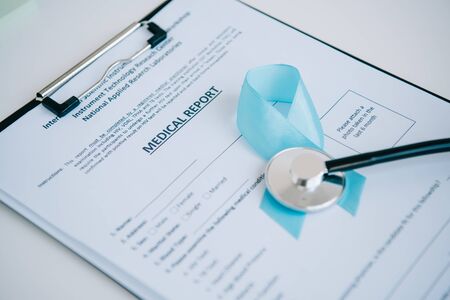 blue awareness ribbon and stethoscope on medical reportの写真素材