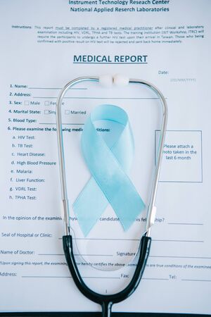 blue awareness ribbon and stethoscope on medical reportの写真素材