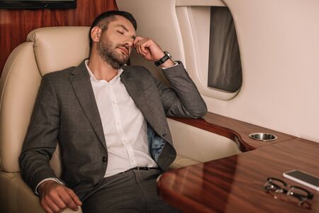 selective focus of businessman with closed eyes sitting in private jetの写真素材
