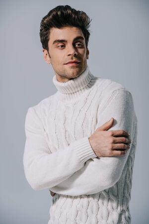 handsome man posing in knitted sweater, isolated on greyの写真素材