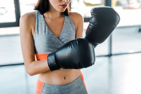 cropped view of sportswoman in boxing gloves in sports centerの写真素材
