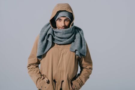 handsome caucasian man posing in hat, scarf and coat, isolated on grey