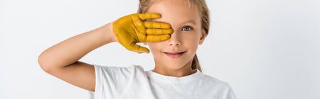 panoramic shot of kid with paint on hand covering face isolated on whiteの写真素材