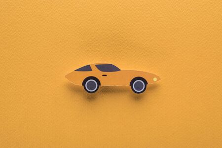 top view of paper cut sports car on orange background, car rent conceptの写真素材