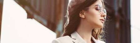 attractive stylish woman posing in beige suit and beret on roofの写真素材