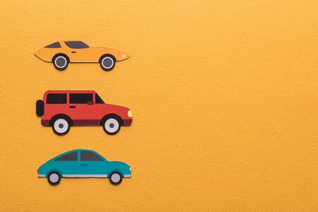 top view of paper cut cars on orange background with copy spaceの写真素材